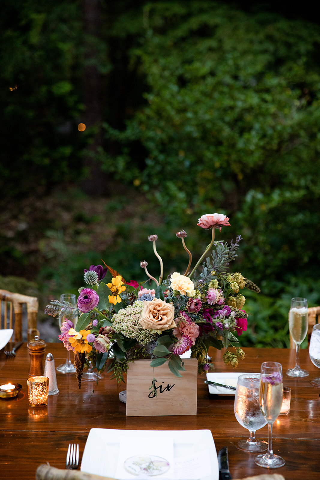 Welcome dinner on the front drive with wildflower centerpieces using ranunculus, chinos, hops, blackberries, persimmons, hops, garden roses, and natural, asymmetrical greenery. RT Lodge and Nashville wedding florist.