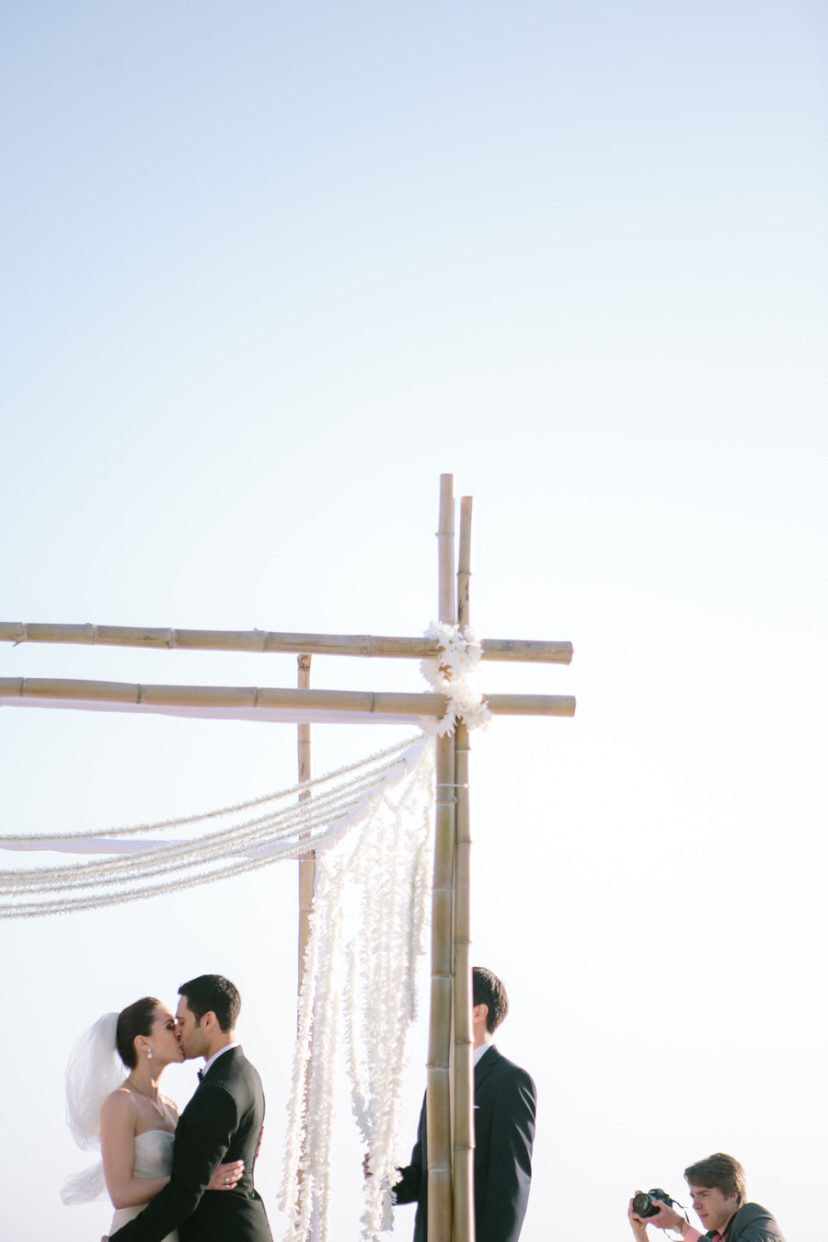 bride and groom's first kiss under chuppah