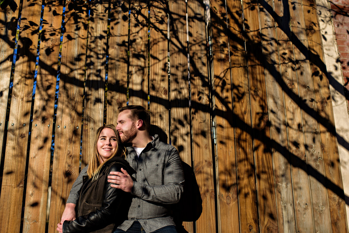 The shadow of a tree frame this fun couple in their engagement session.