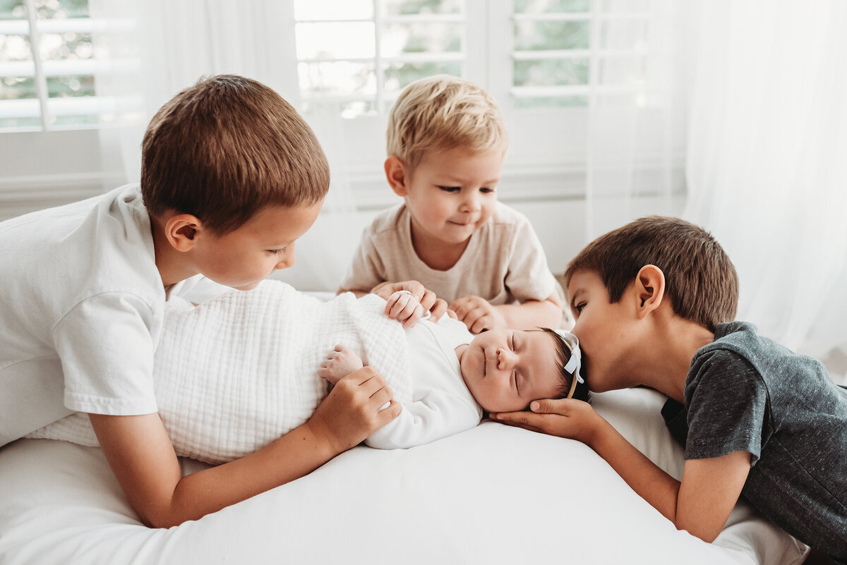 newborn baby sister with her three brothers taken by denver photographer