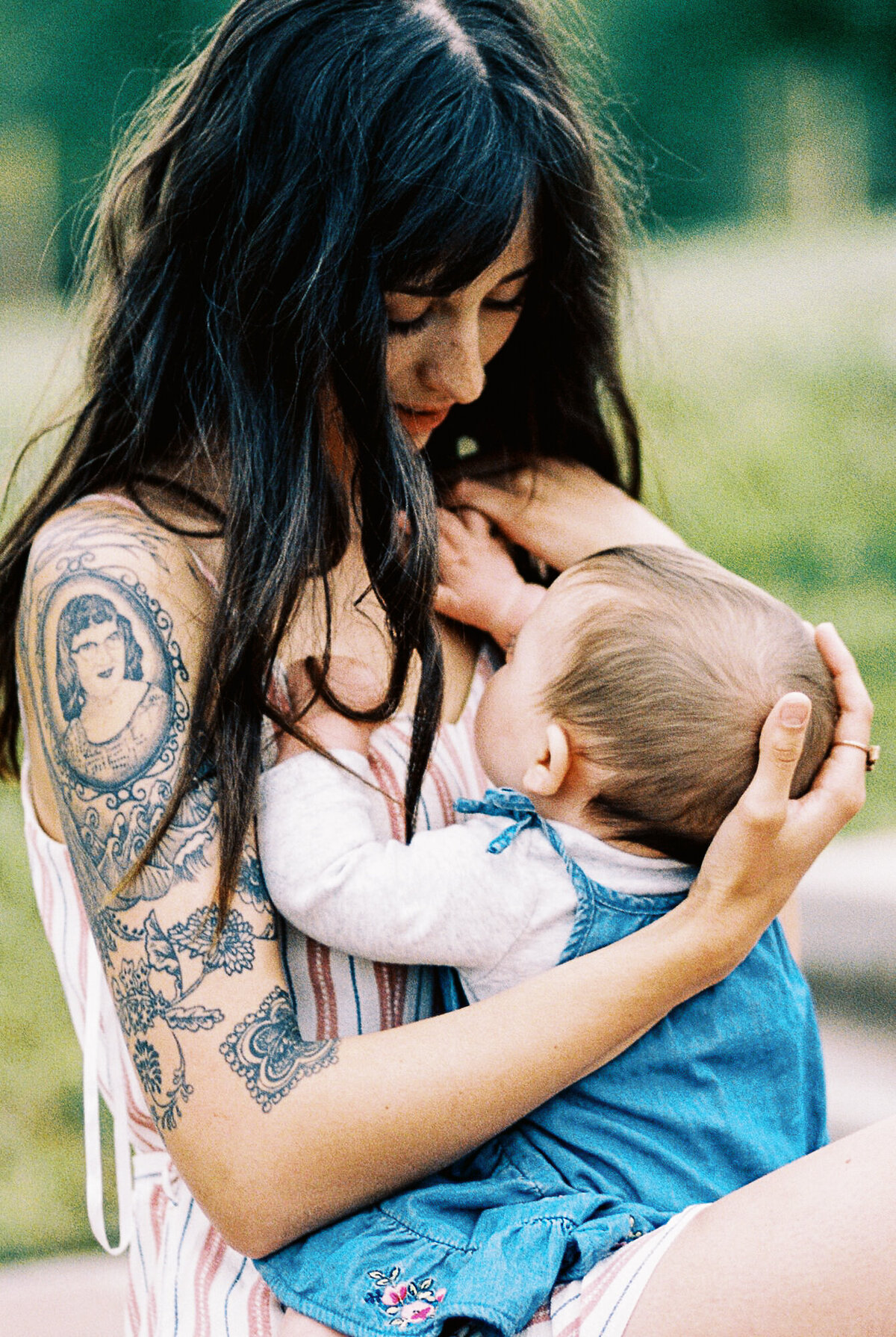 a woman with long hair looks down at her baby
