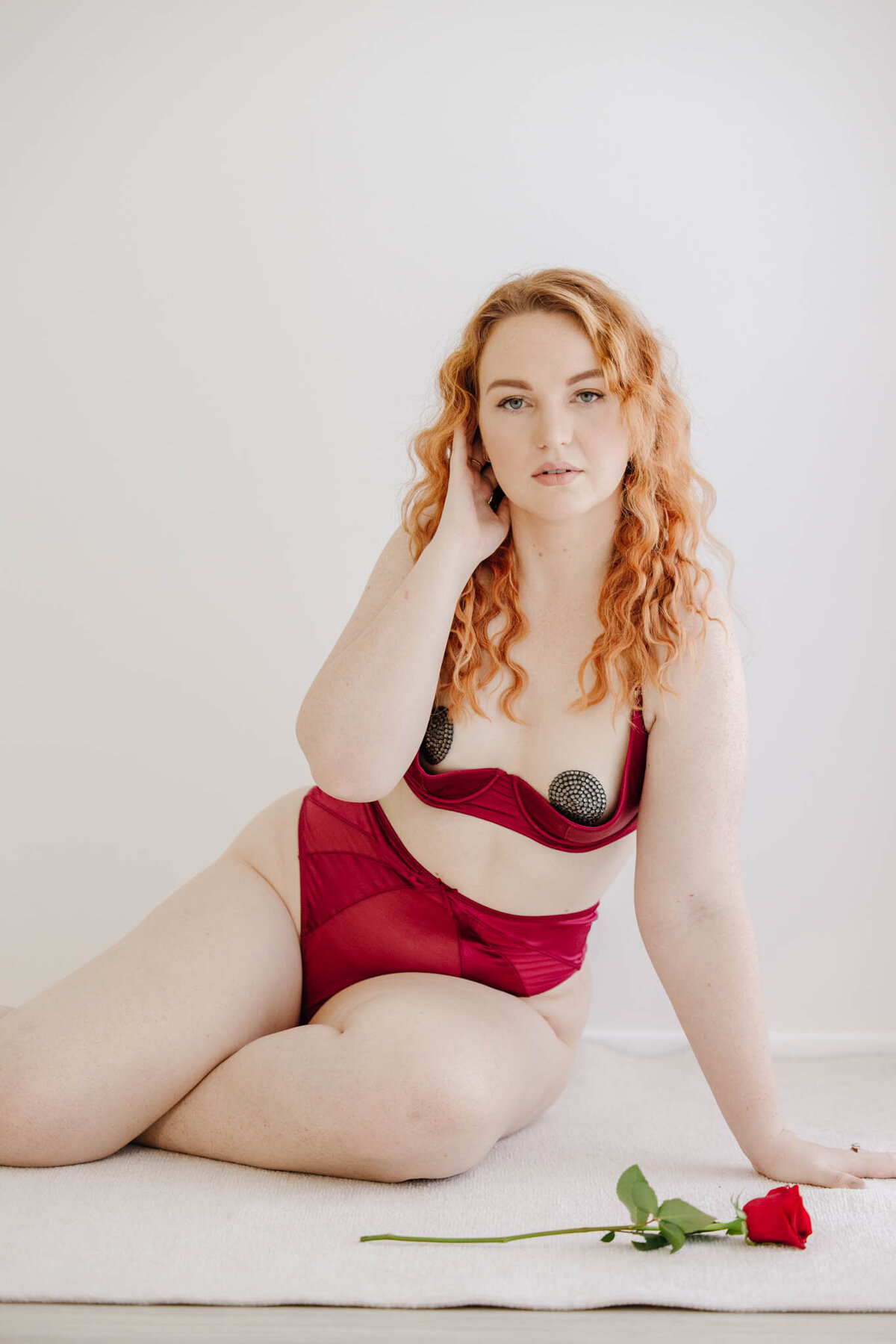 woman in ruby lingerie poses with alyce holzy boudoir