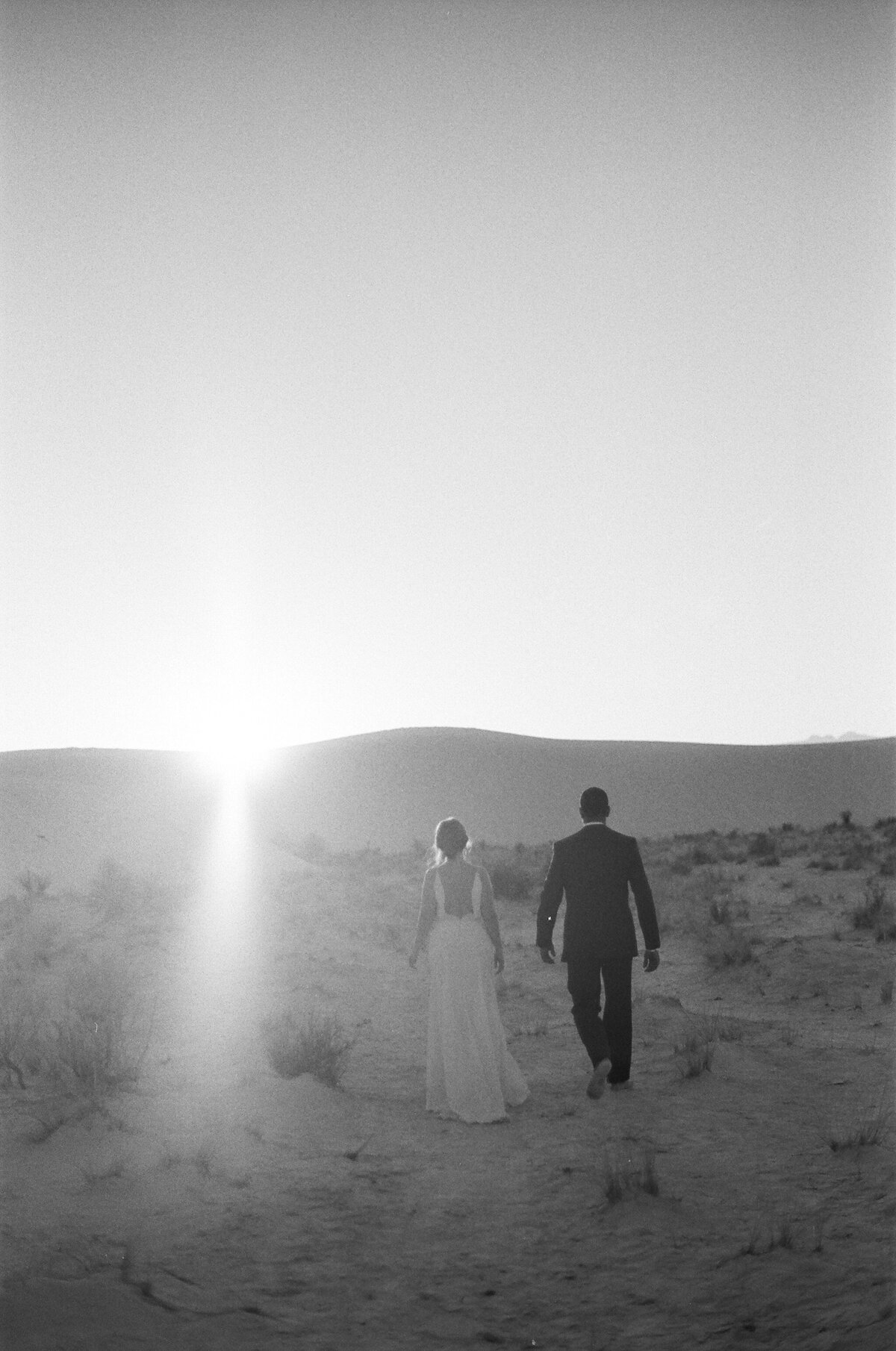 couple walking into sunset in white sands new mexico