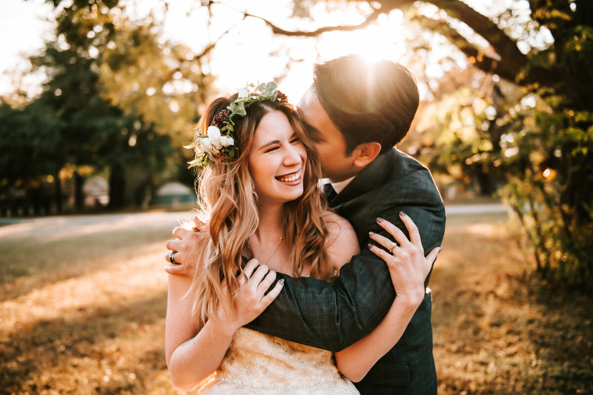 Couples Photography, Man hugs and gives a kiss to his girlfriend, she smiles and wears a floral crown