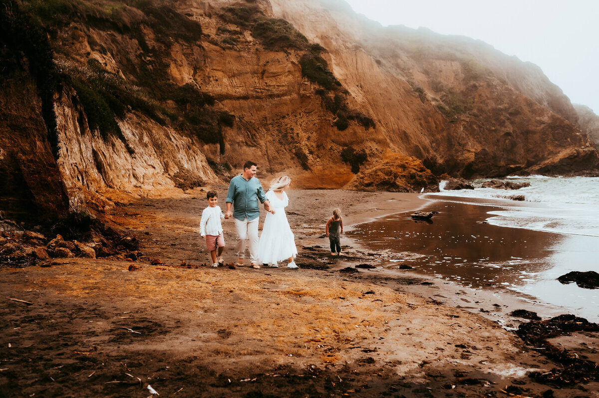 Family walking down the beach below the Marin Headlands