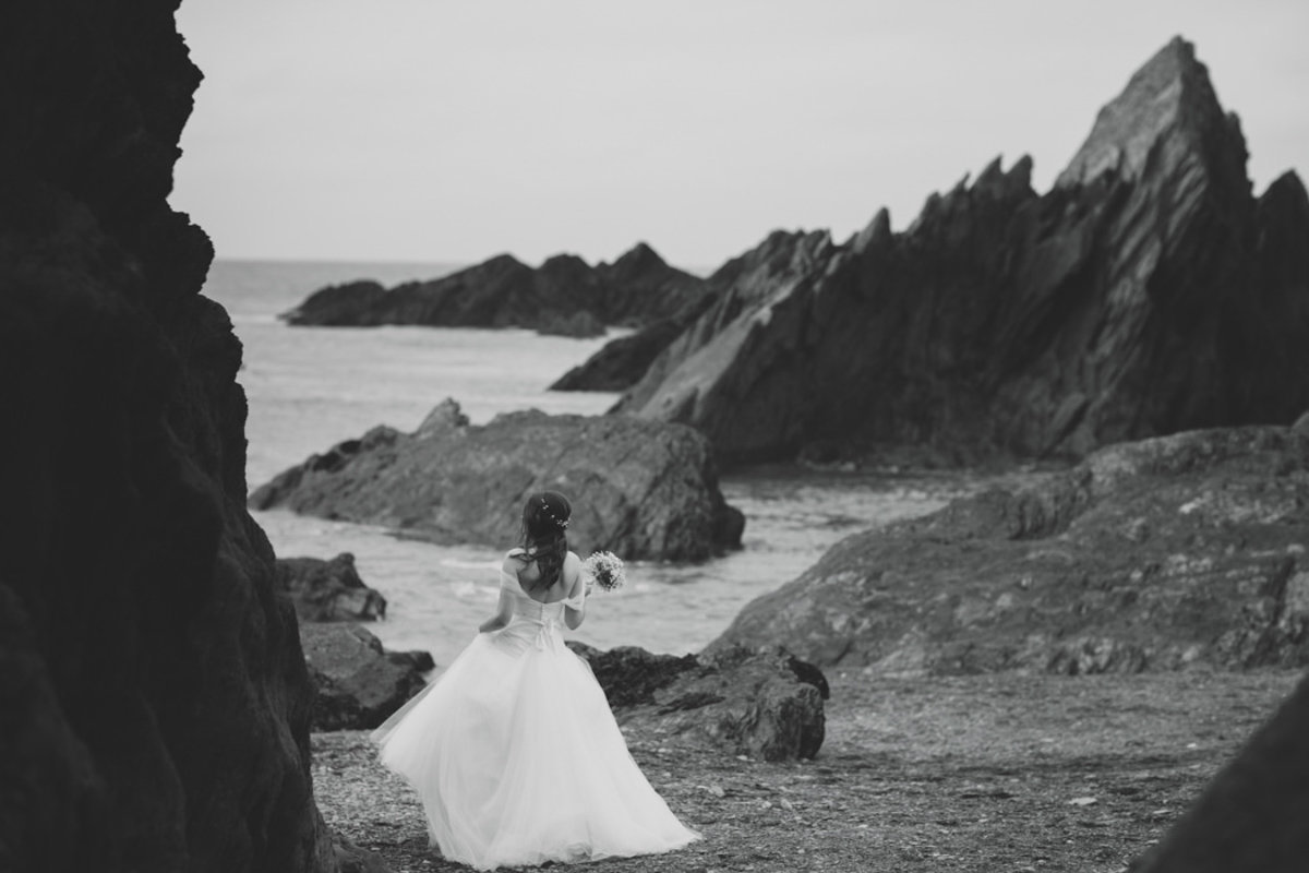 Black and White photo of Bride at Tunnels Beaches in Devon on the rocks