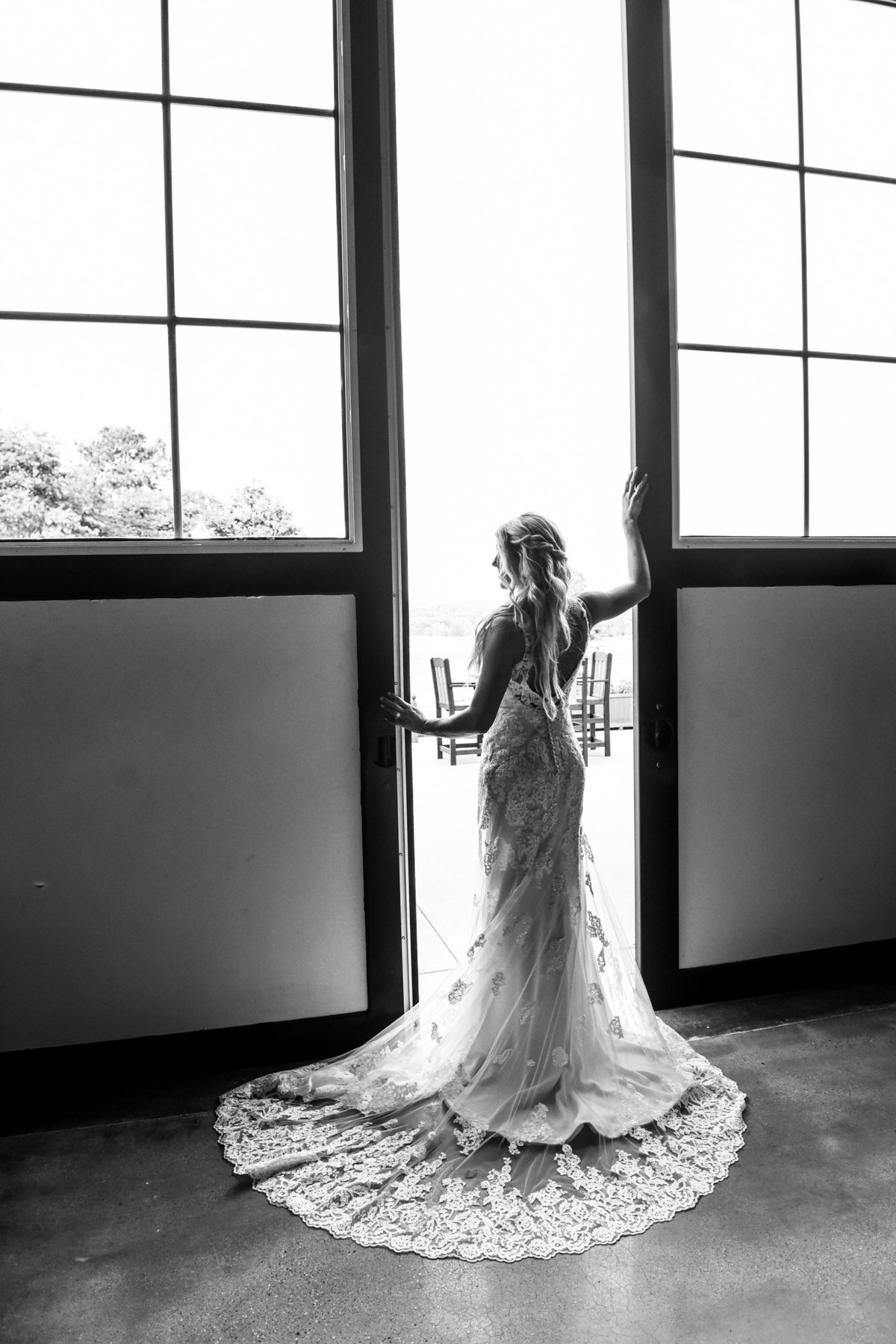 Black and white image of a stunning bride posing at a barn door at Mount Ida Farm in Charlottesville. Richmond and Charlottesville wedding photographers
