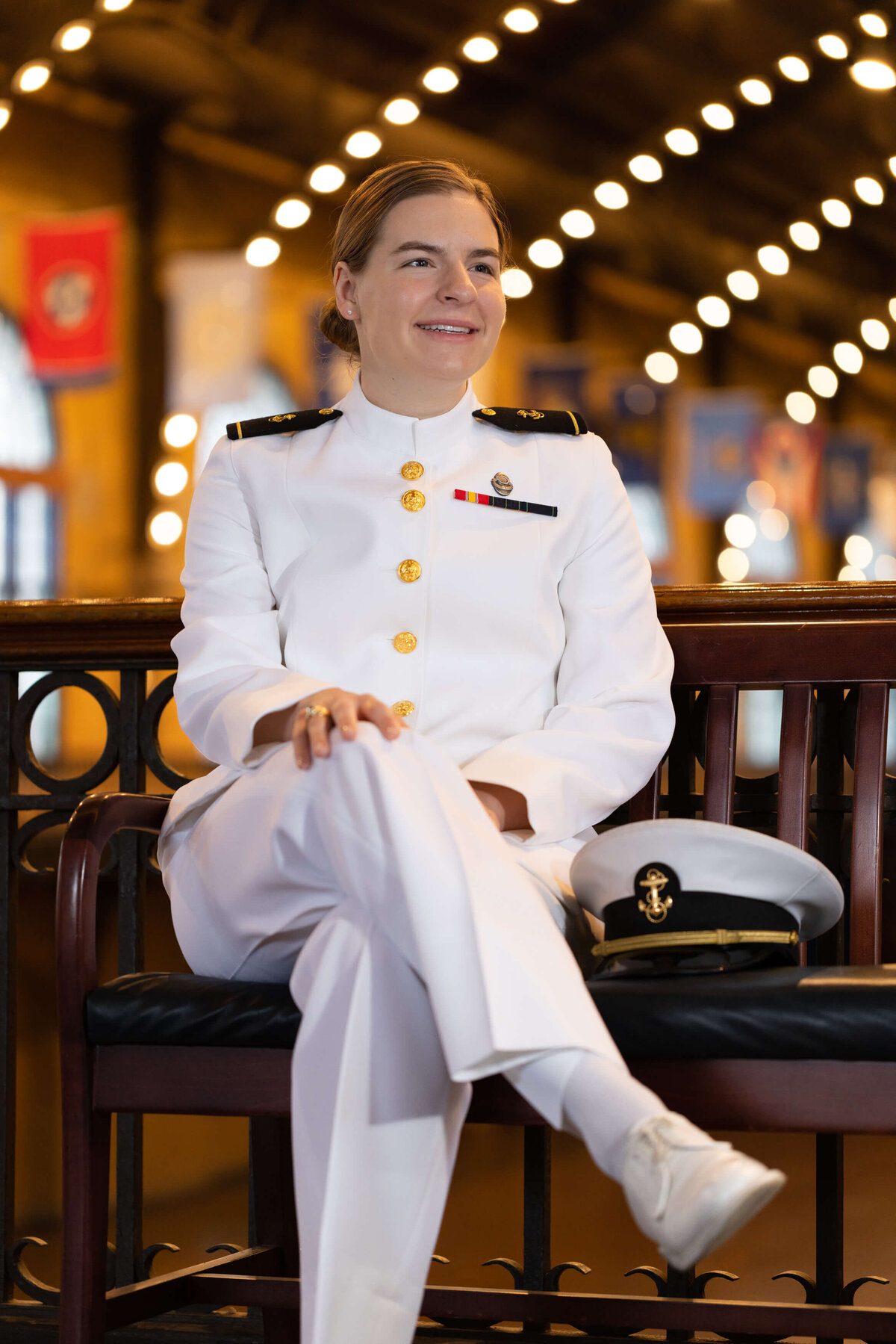Naval Academy senior portrait in choker white uniform with bokeh lights in Annapolis.