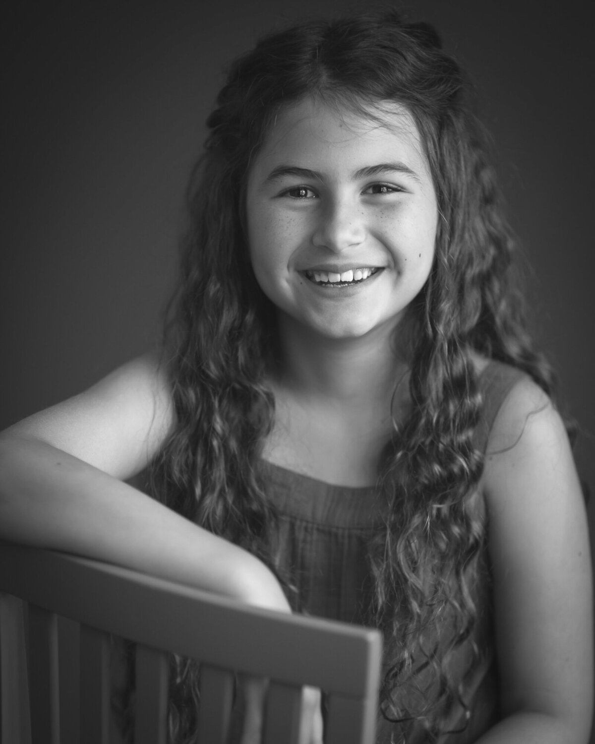 black and white studio portrait  of a ten year old gril very happy and smiling