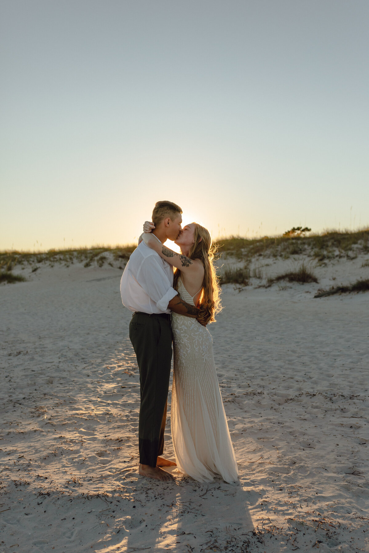 newlyweds kiss at sunset after intimate wedding