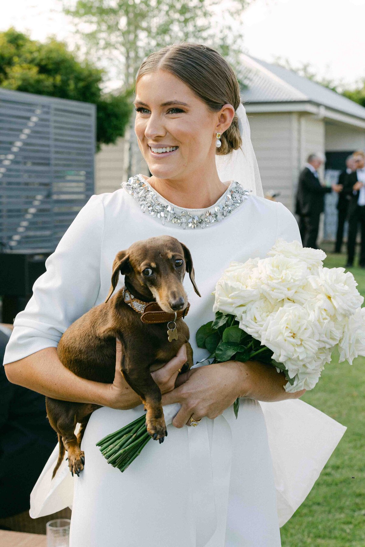 Bride holding her dog and bouquet