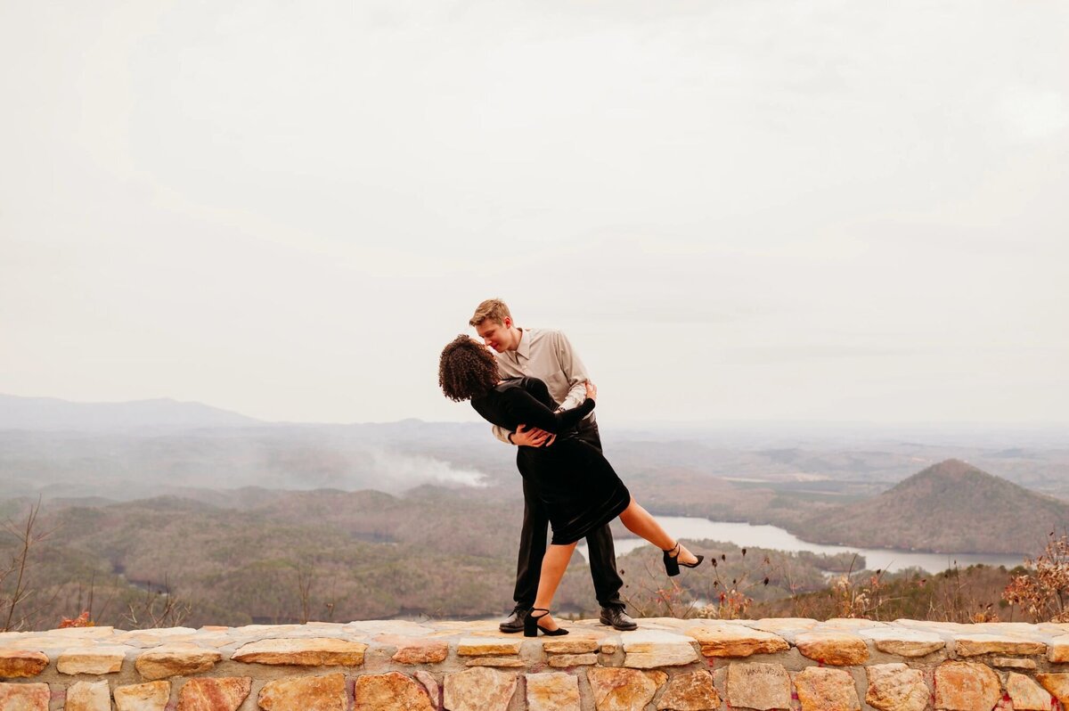 photo of man and woman dancing in front of mountains