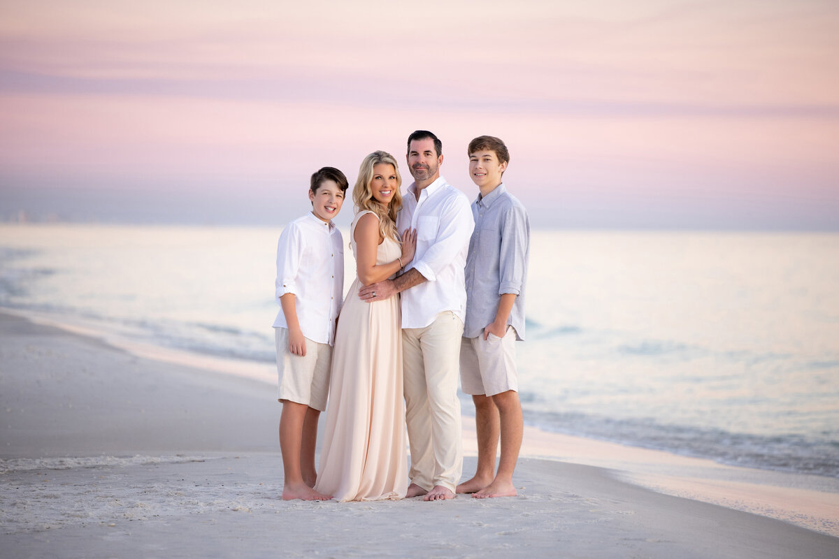 A family standing close together at the water's edge