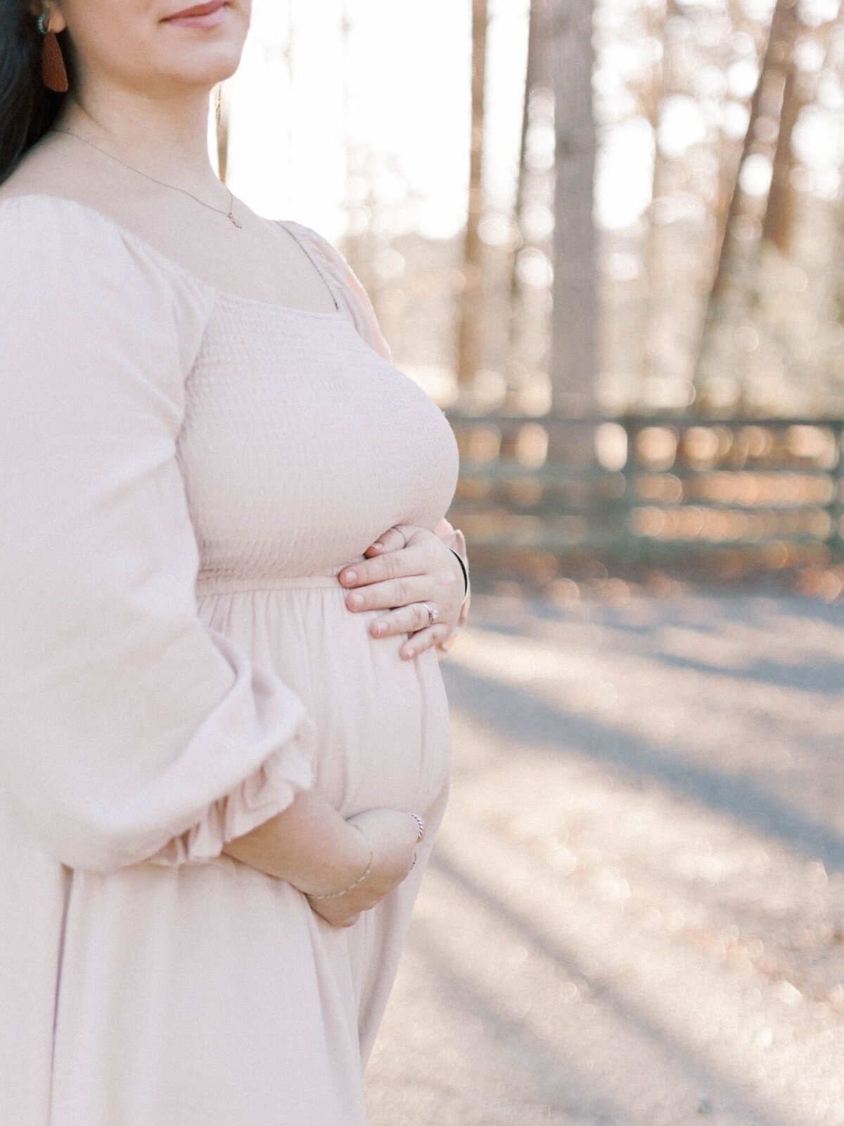 Woman holds her pregnant belly.