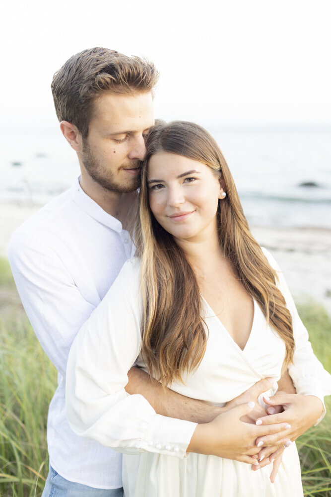Couple hugging on the beach for engagement photos