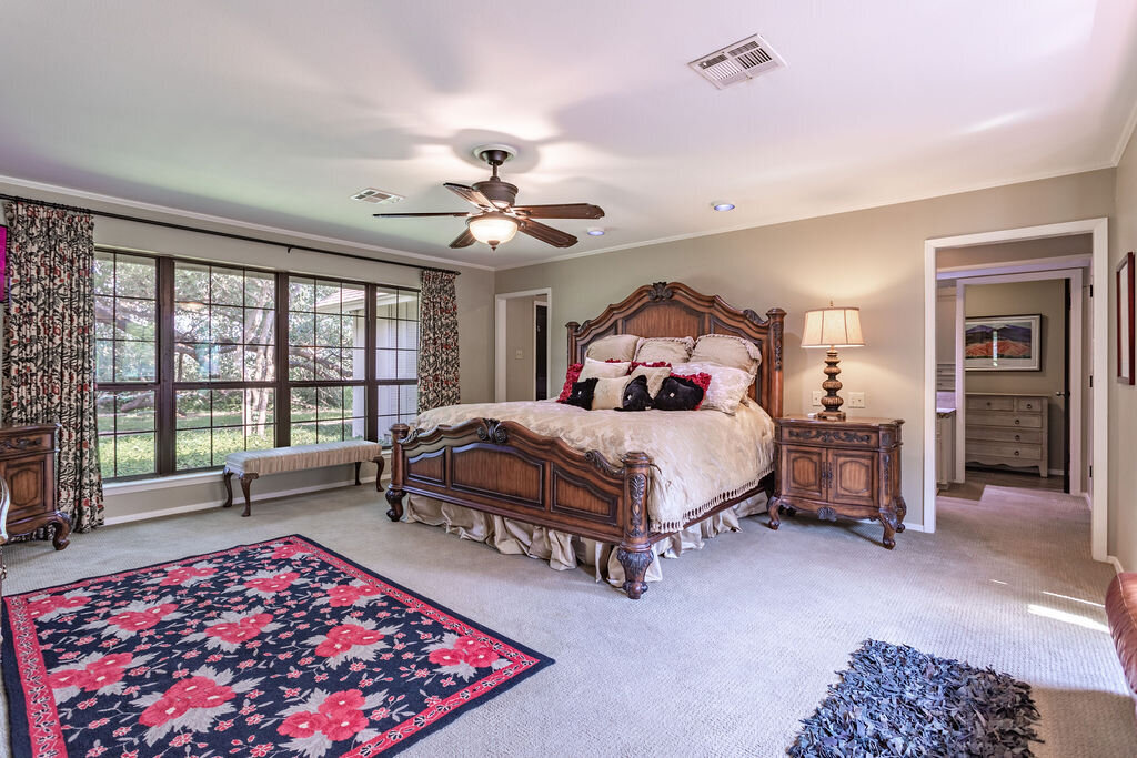 Spacious bedroom with comfortable bedding in this 5-bedroom, 4-bathroom vacation rental house for 16+ guests with pool, free wifi, guesthouse and game room just 20 minutes away from downtown Waco, TX.