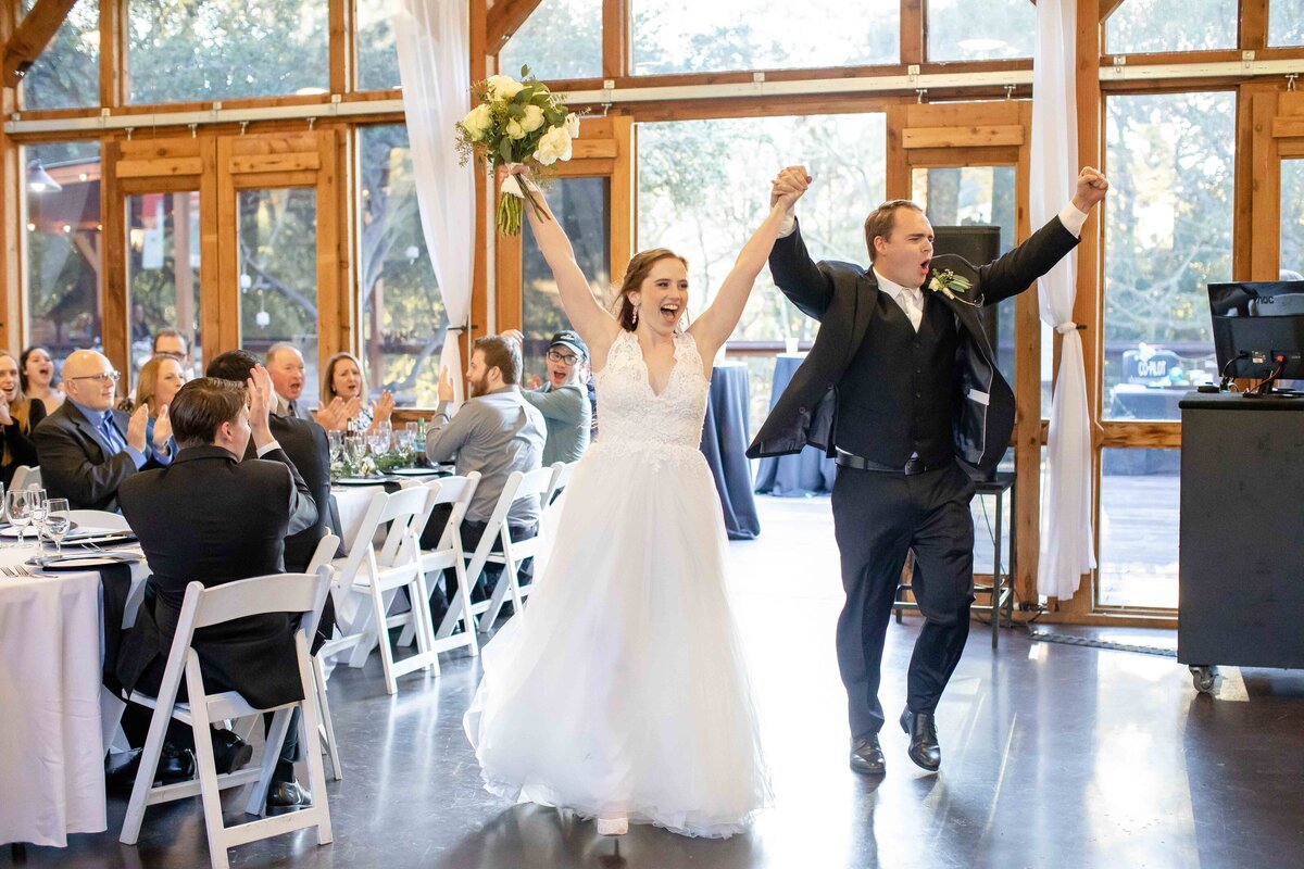 bride and groom cheer as they enter reception at Milltown Historic District in New Braunfels Texas