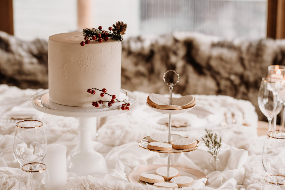 White Christmas wedding cake with snowflake stencil and berries and shortbread biscuit treats