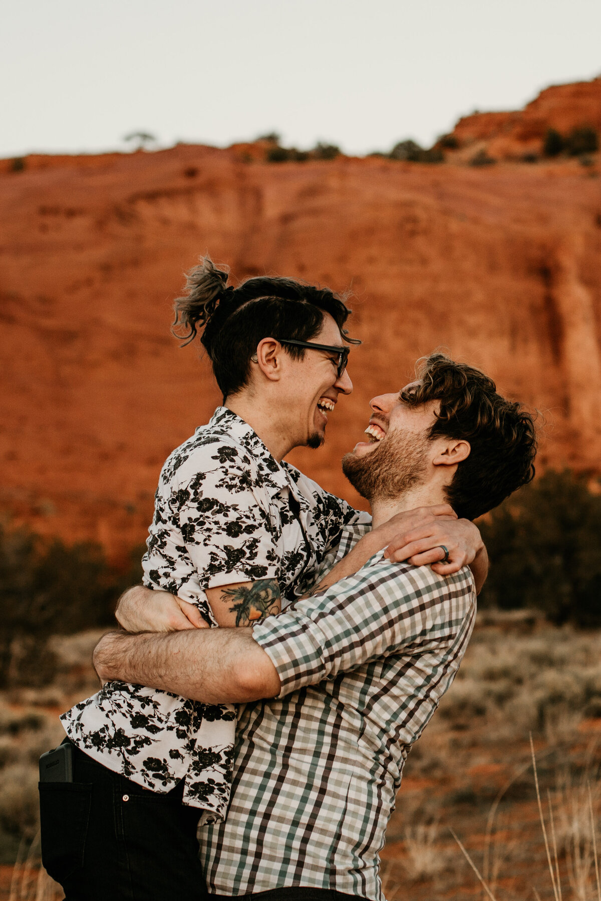 man holding fiancé laughing together