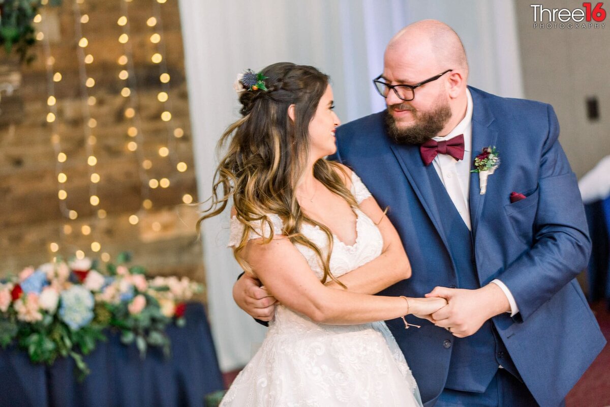 Bride and Groom gaze into each other's eyes during their first dance prior to him twirling her