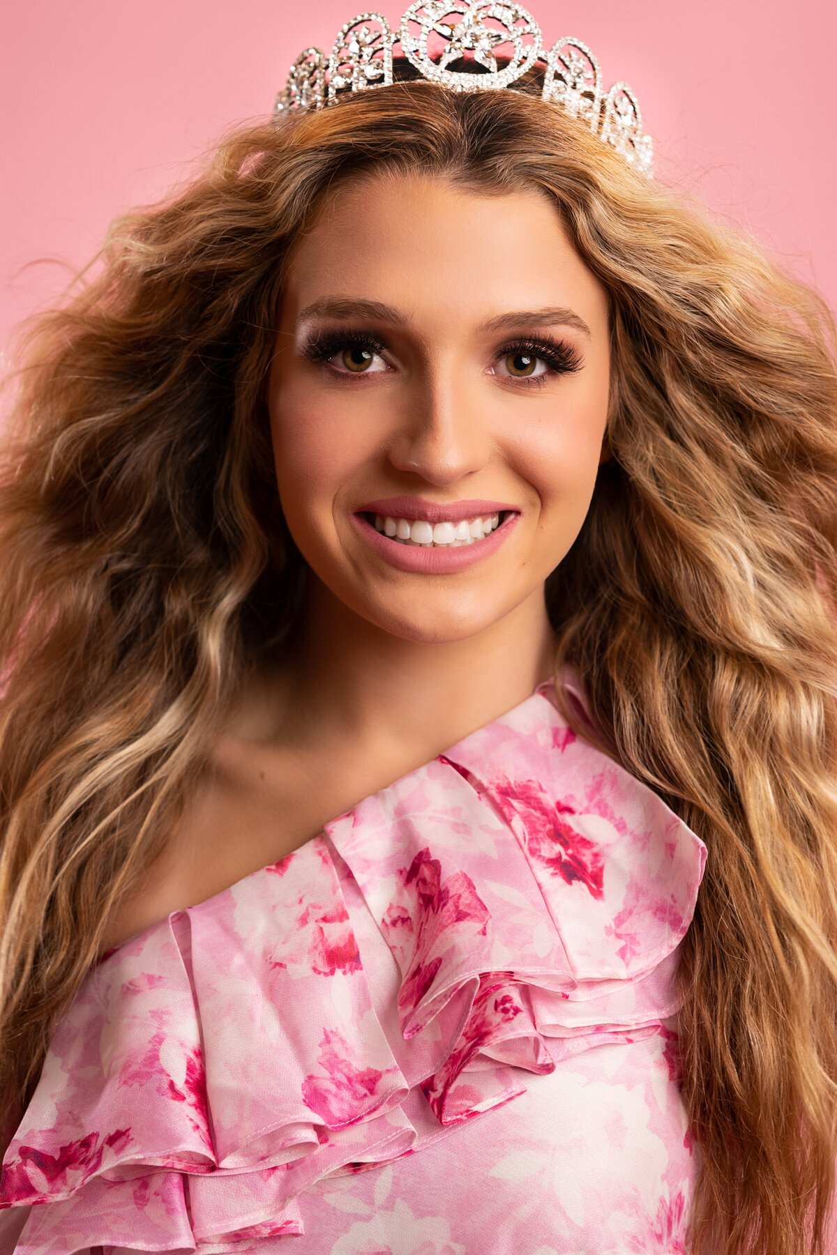 headshot of a teenager wearing a crown and smiling to the camera