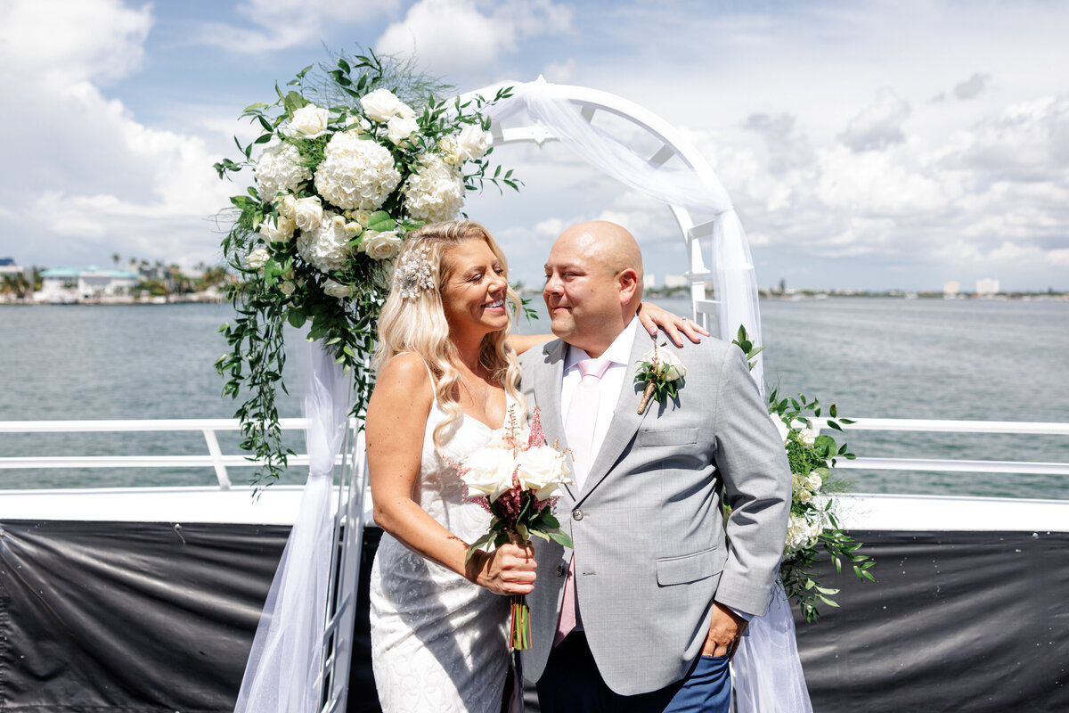 Blue and white floral ceremony arch set up on the yacht deck with views of the St. Pete shoreline.