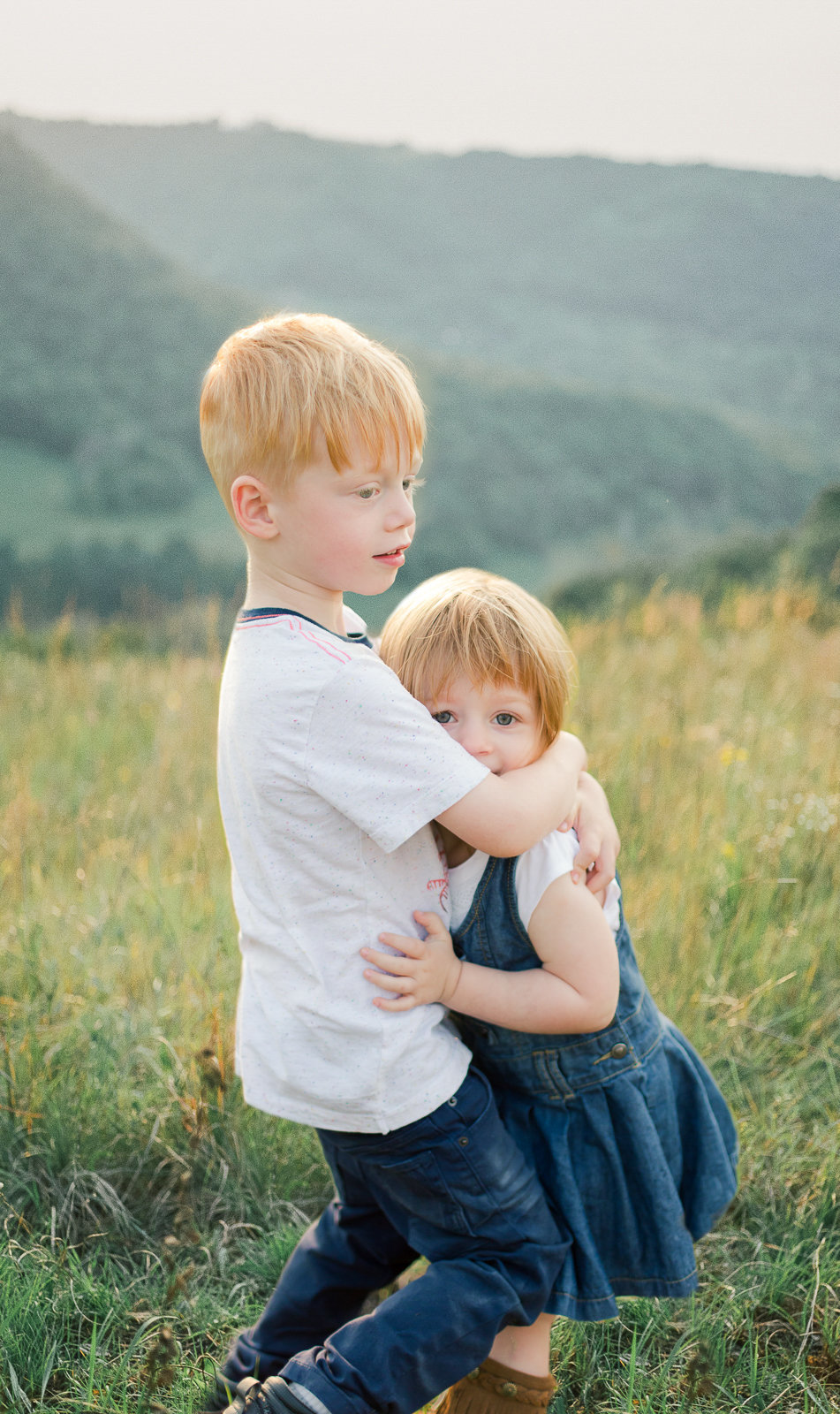 siblings hug in summer grasses of great river bluffs state park