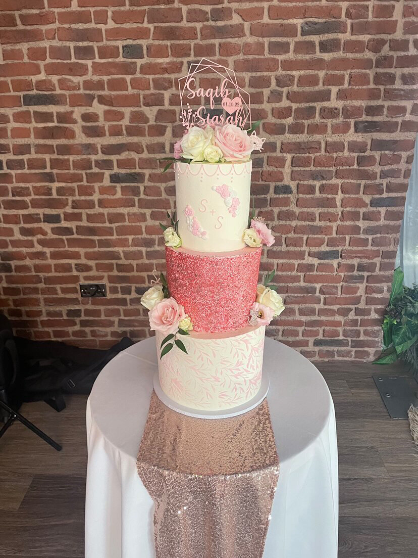3 tier wedding cake with rose gold sparkle tier monogram and stencil and flowers