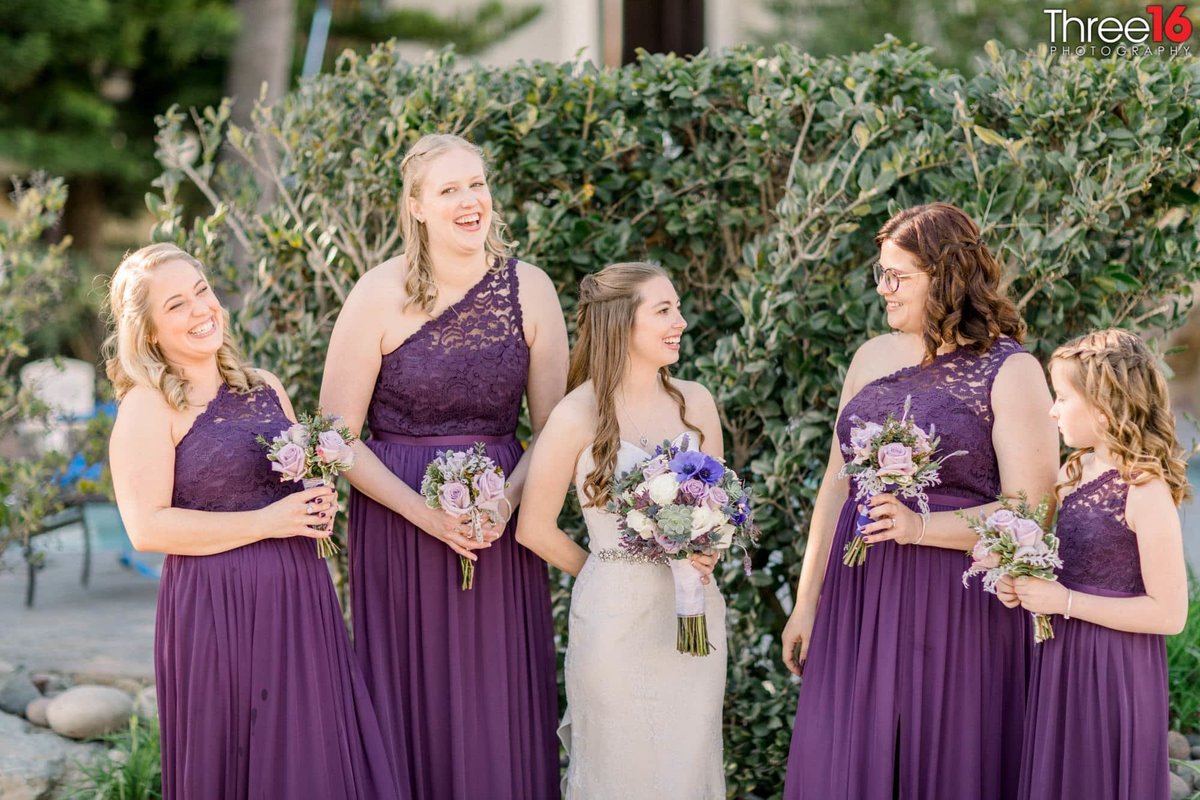 Bridesmaids dressed in purple share a laugh with the Bride prior to the wedding