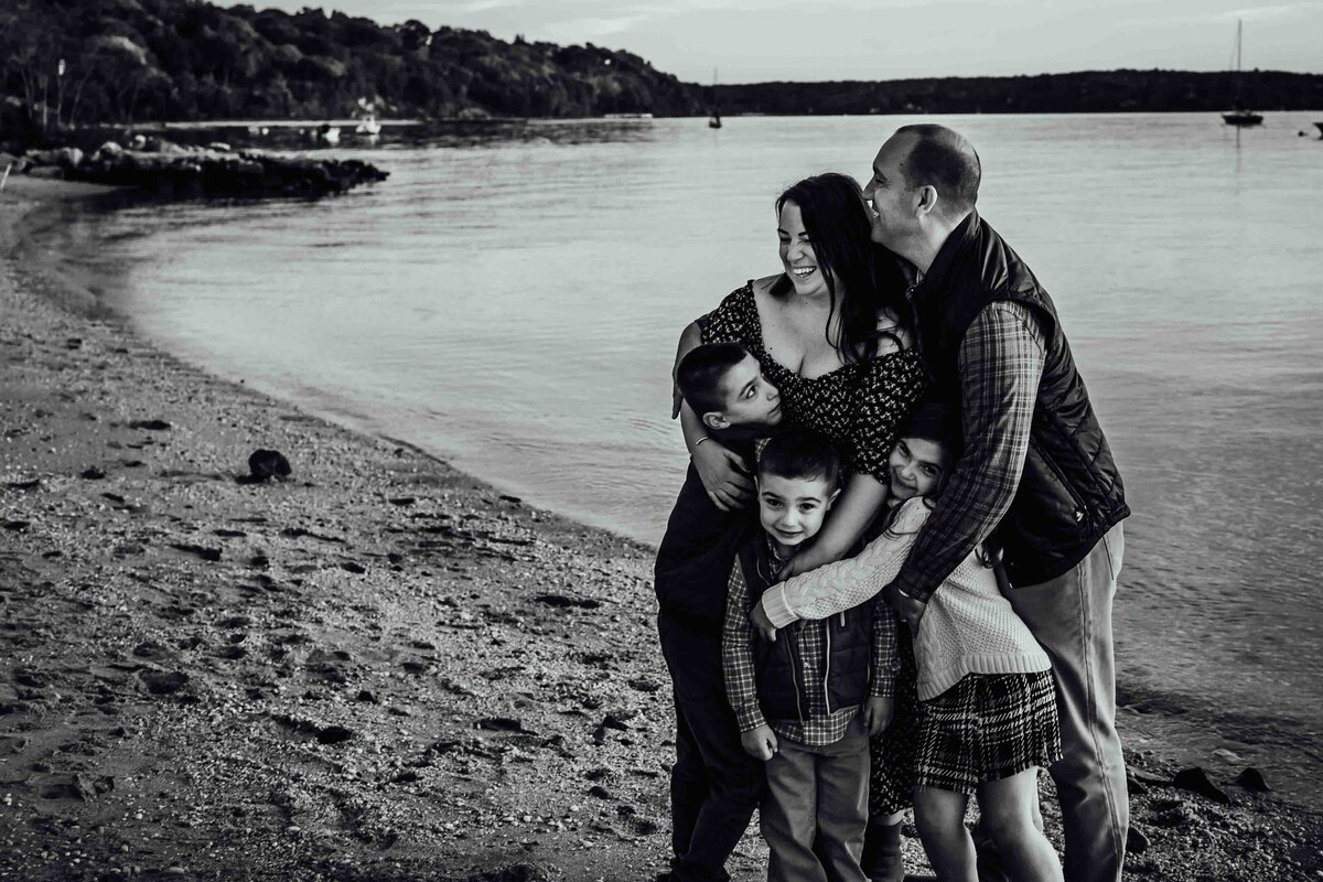 family hug on beach lloyd harbor photo session