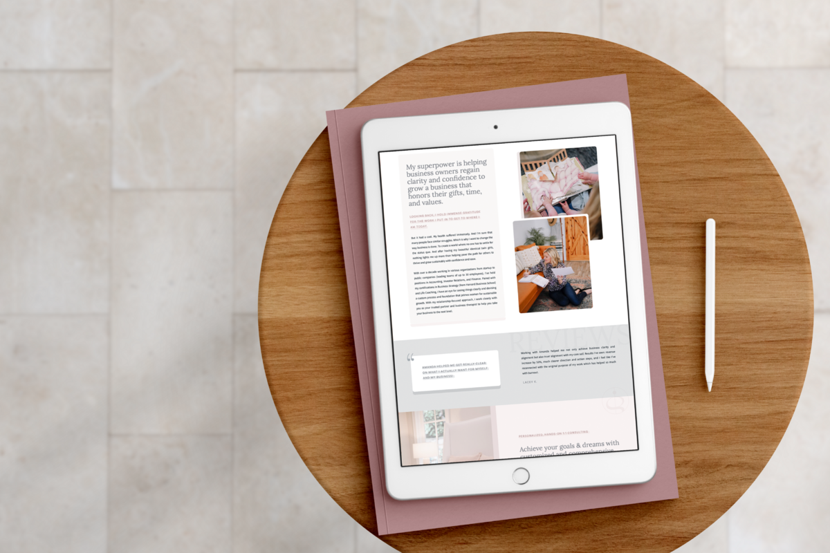 Clean, modern website with neutral colors on white iPad on top of pink journal on wooden stool on top of white tiled floor