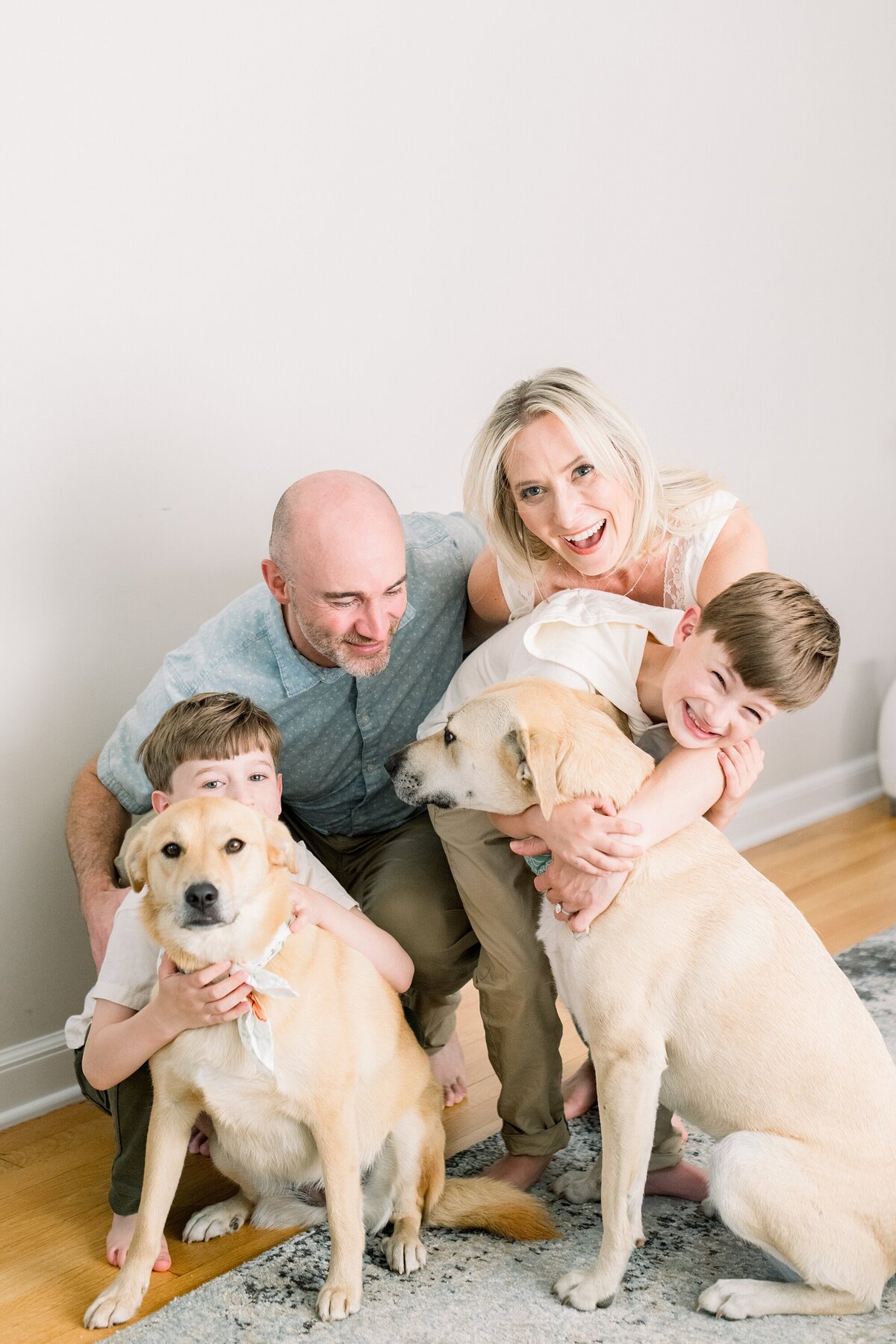 family laughing with two dogs