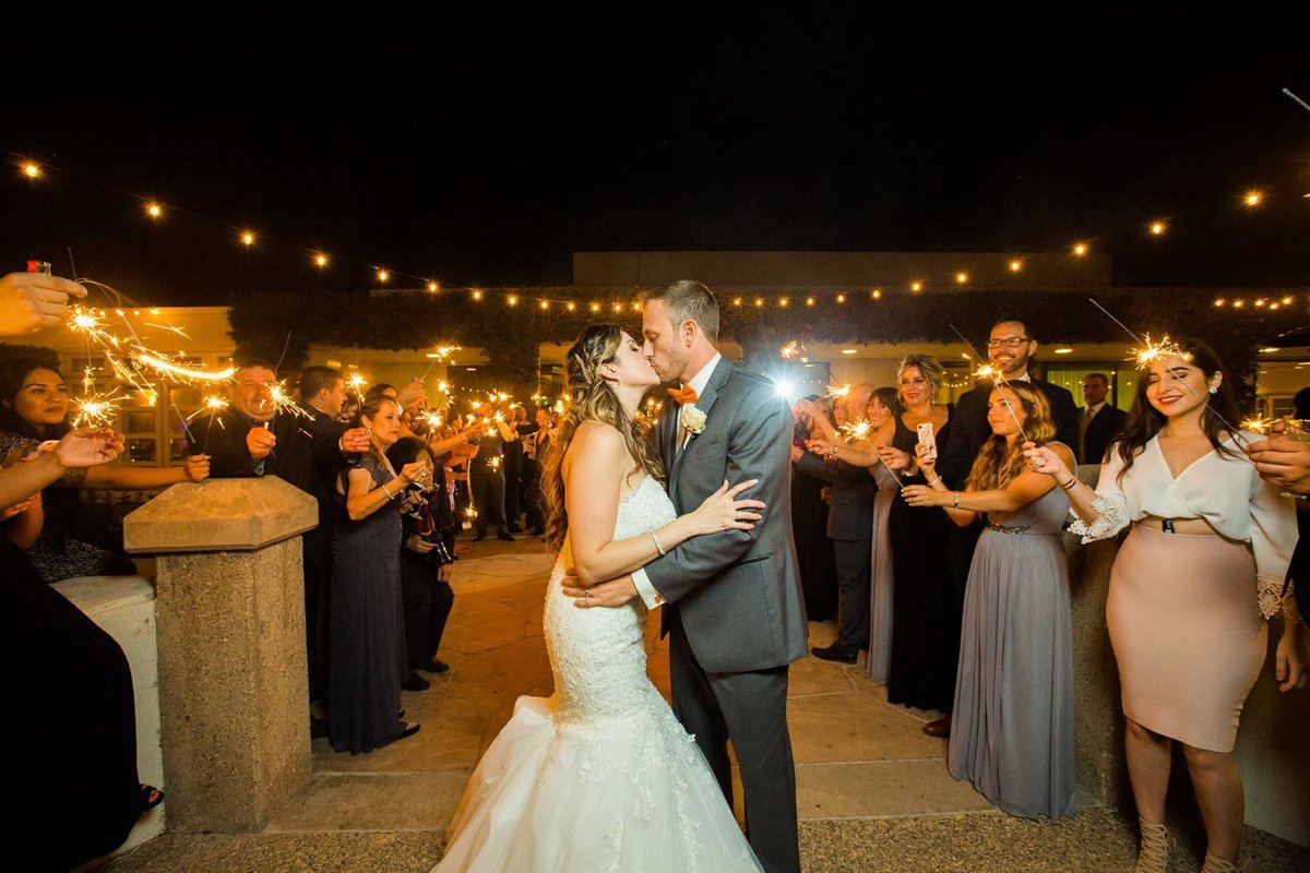Bride and Groom kiss after walking the tunnel of sparklers