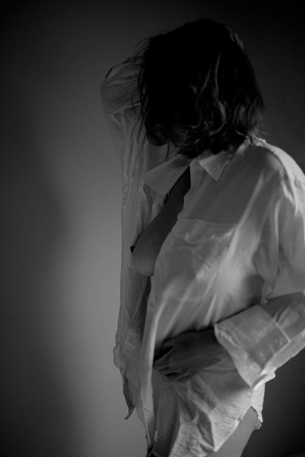 En kvinne i hvit skjorte under boudoirfotografering i Oslo.