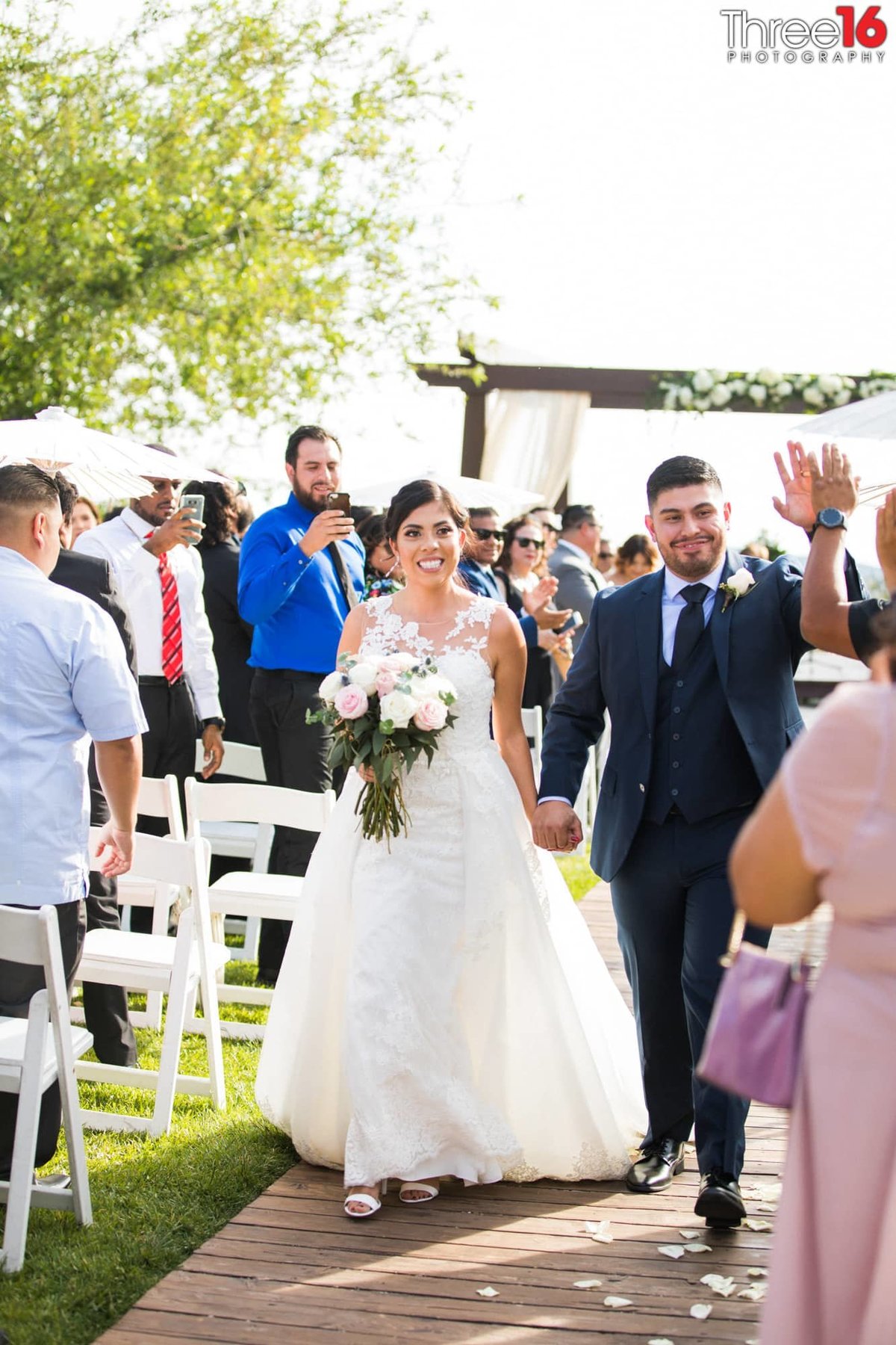 Newly married couple walk together down the aisle
