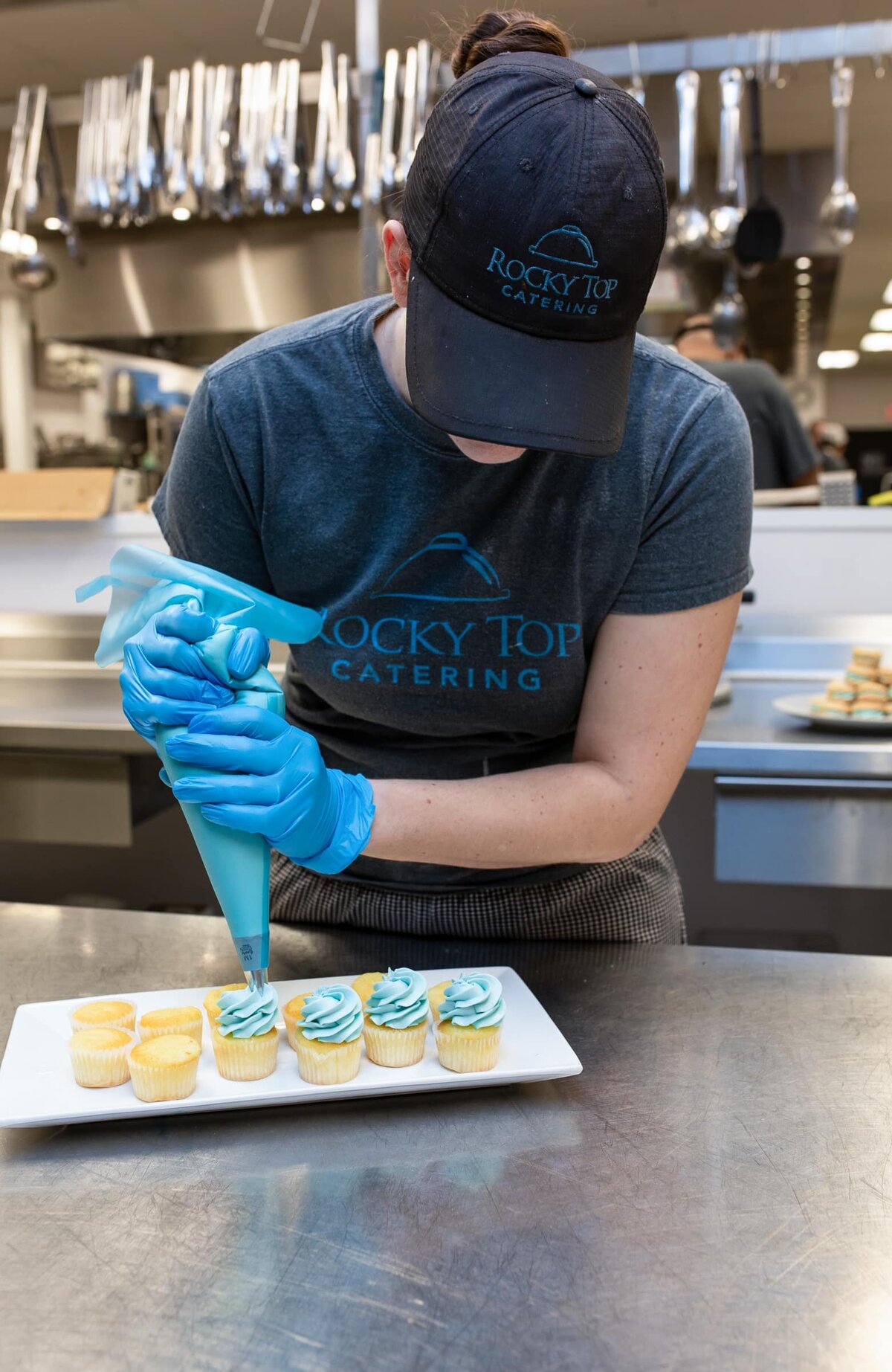 branding photographer in Raleigh. A baker preparing vanilla cupcakes with blue frosting.