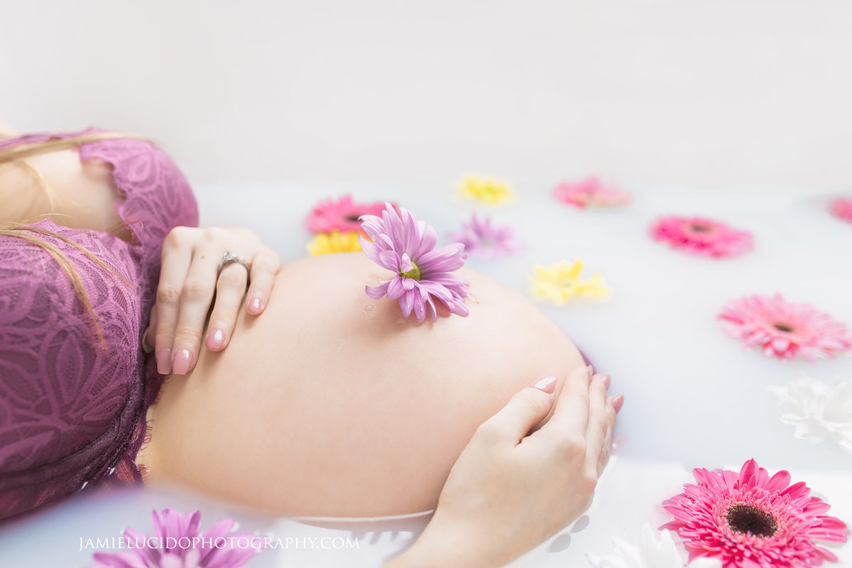 charlotte newborn photographer creates a beautiful portrait of a mother's belly surrounded by milk and flowers