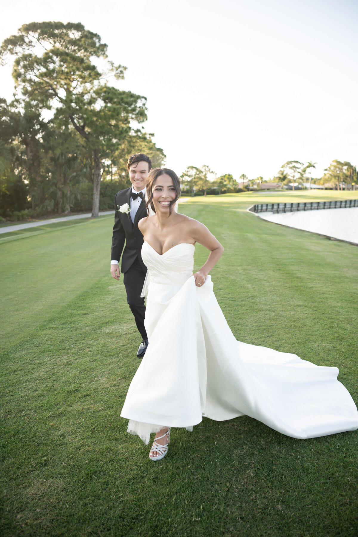 Bride and groom running on Ritz Carlton Golf course in Naples