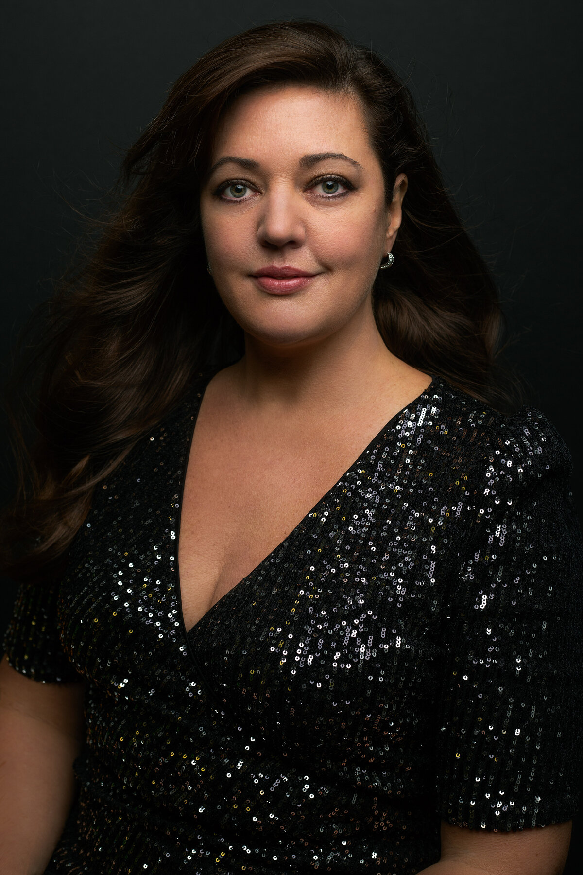 A woman with dark brown hair and black sequin dress poses for a portrait for Janel Lee Photography studios Cincinnati Ohio