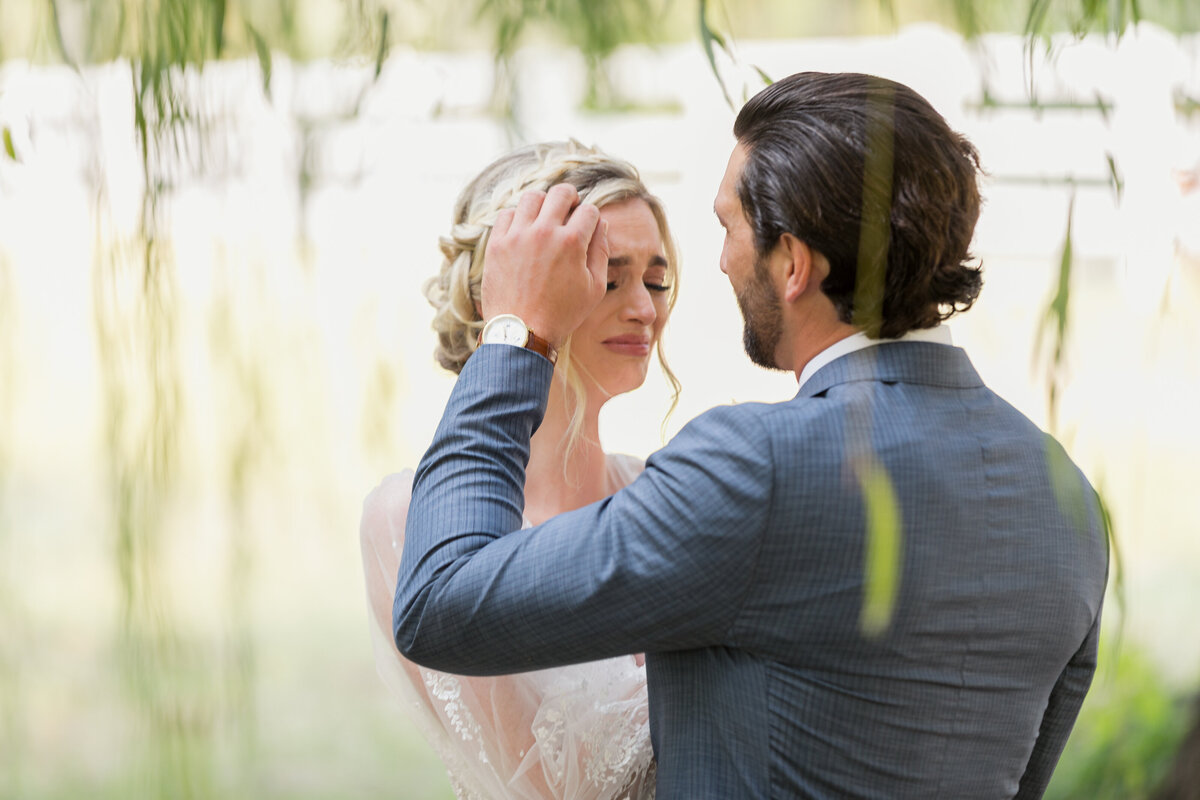 man touching bride's hair and face