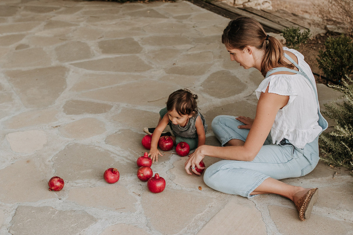 mother son playing with pomegranates