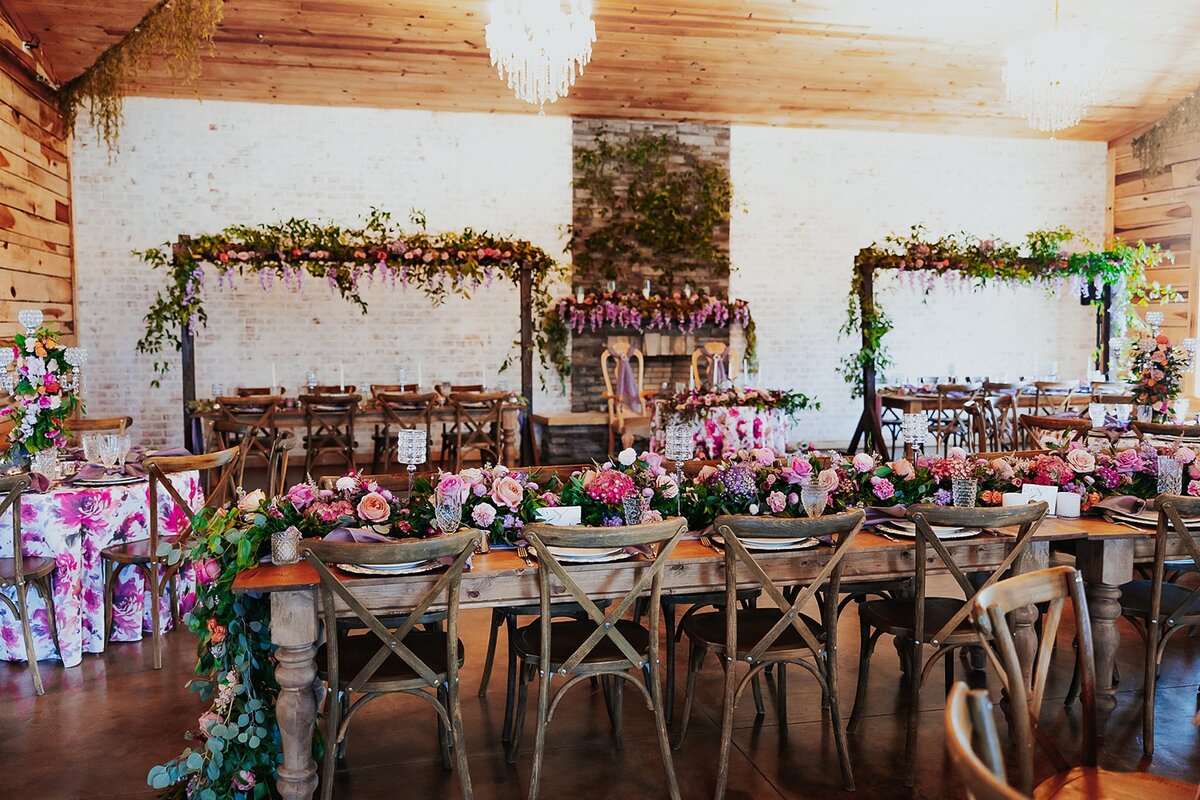 Pink, purple, peach and white elaborate florals in elegant and rustic wedding barn