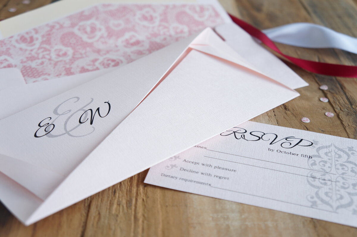 Pink origami wedding invitation with elegant script font and RSVP card