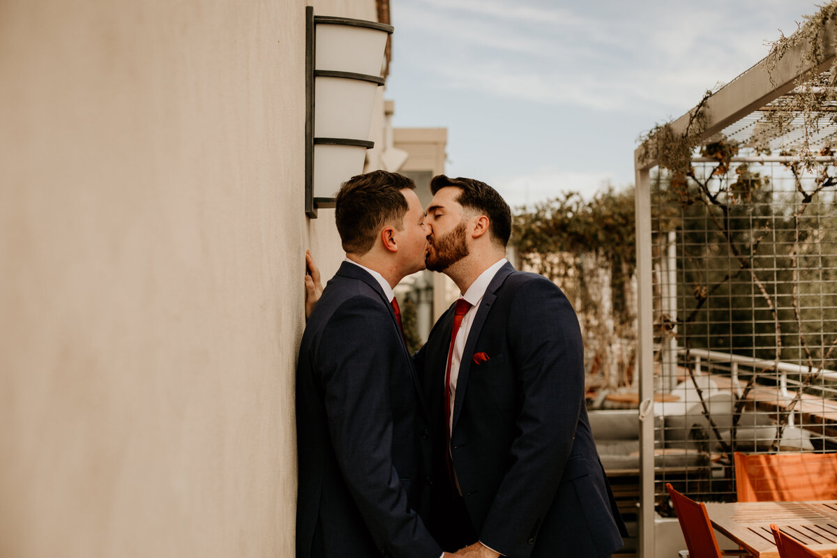 two grooms kissing on a balcony in downtown Albuquerque