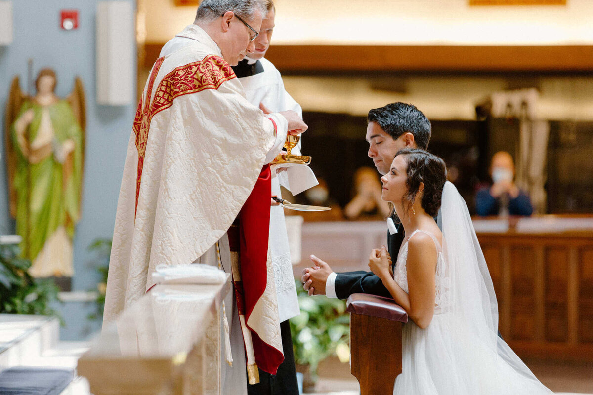 17-kara-loryn-photography-bride-and-groom-recieve-holy-communion