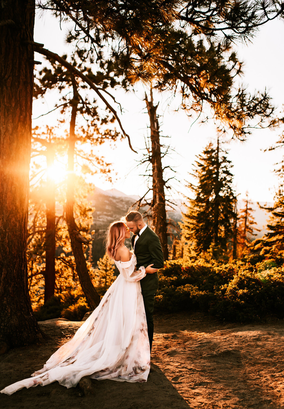 Couples Photography, Man in a blue suit holding and kissing right under the sunset in the forest.