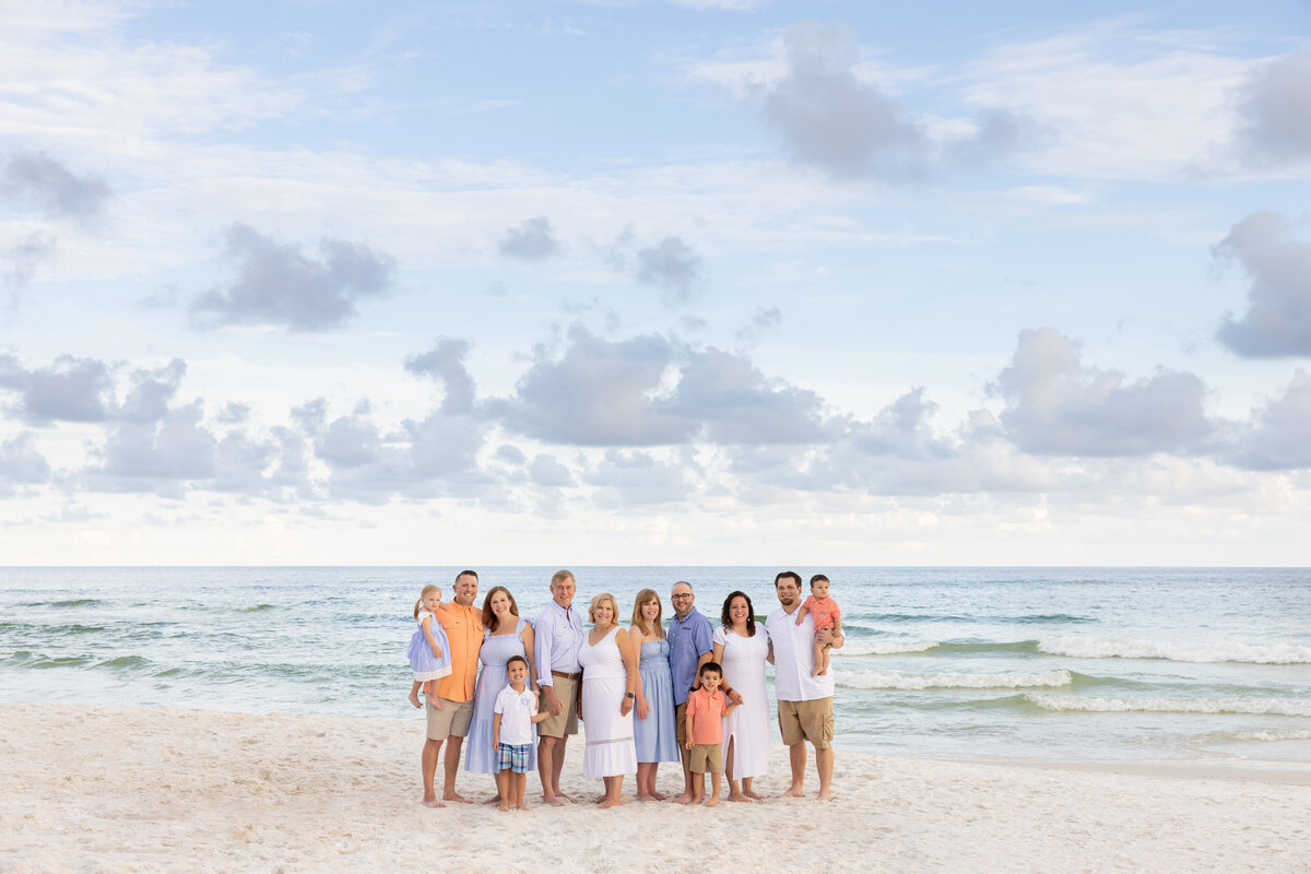 A family standing in the sand together at the beach