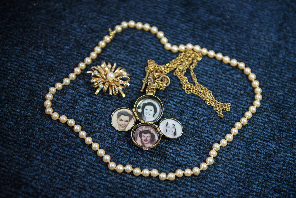 Bride jewely with necklace and old family photos.