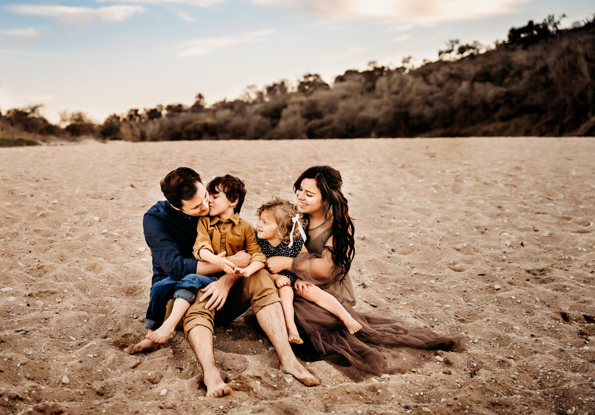 Mom and dad hold their kids in the sand