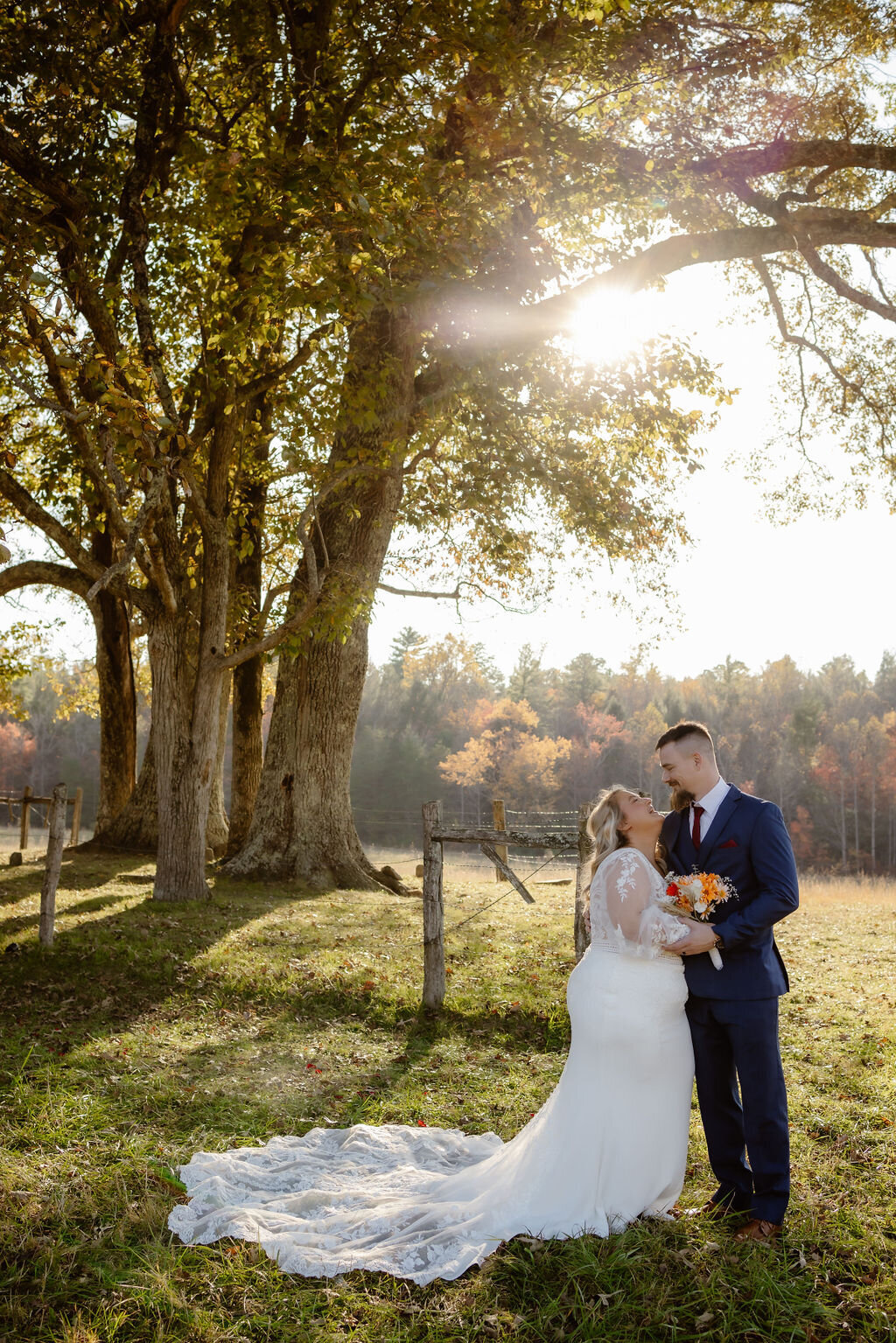 photographers in gatlinburg tn captures romantic wedding photos in Cades Cove with couple embracing near a grove of trees at sunset while they elope to Gatlinburg  